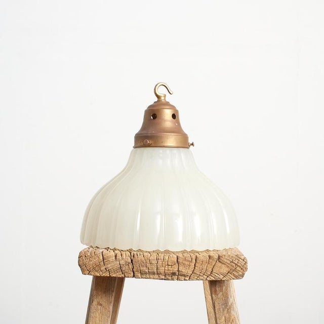 A moonstone pendant light with a pressed opaque glass shade has a traditional fluted design. The light retains its...