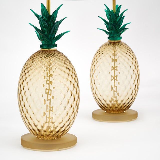Pair of lamps made of hand-blown glass from Murano, Italy. Each lamp depicts a stylized pineapple – known as an...