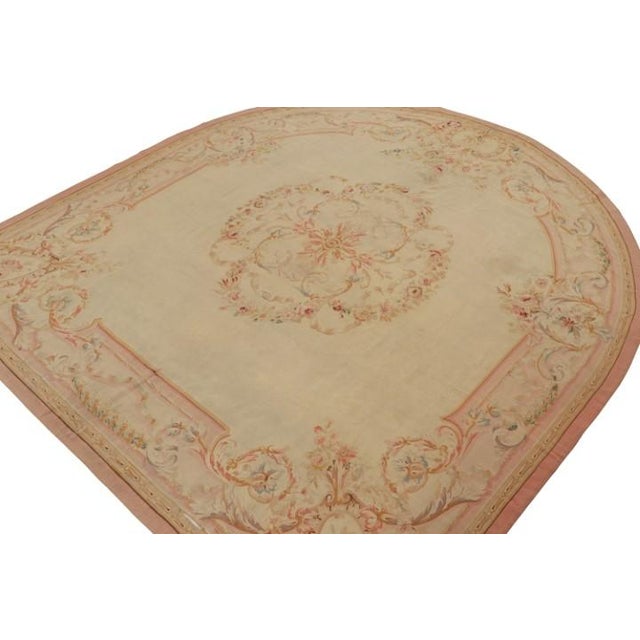 Handwoven in wool and hailing from France circa 1890-1900, this 11x12 antique Aubusson flatweave and round rug is an...