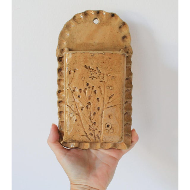 Vintage studio art pottery wall pocket with floral design. No makers mark. One small chip on the bottom edge. Pictured.