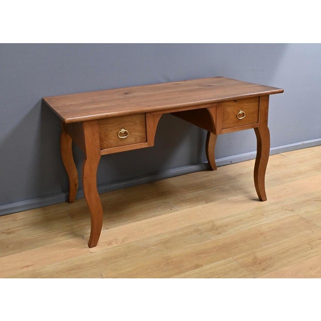 This solid cherry desk table dating from the second half of the 19th century, has a rectangular top made of wide, well-...