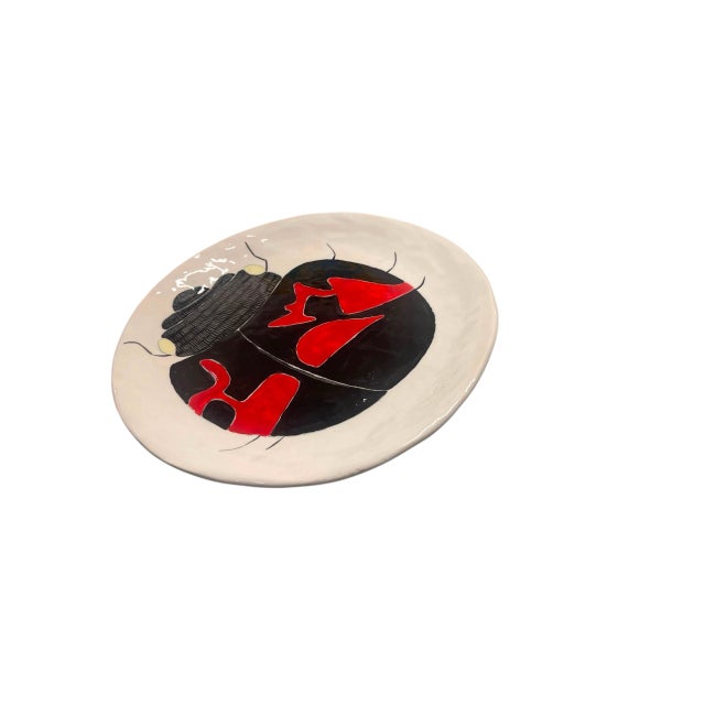 This striking vintage decorative ceramic plate features a bold, avant-garde interpretation of a ladybug or beetle, making...
