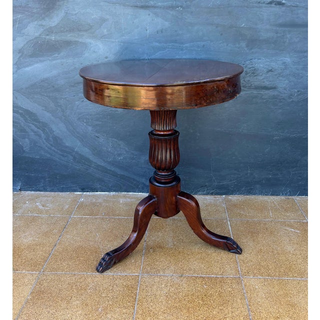 English Regency-style round side table, dating to the mid 20th century. The table features a circular top supported by a...