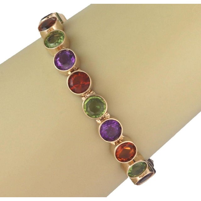 The Multi-Color Bezel Set Round Gems 14k Yellow Gold Link Bracelet is a stunning piece of vintage and antique jewelry....