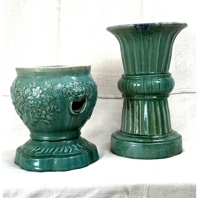 A serene pair of early 20th-century Vietnamese Annamese green glazed garden forms — one drum stool with pierced sides and...