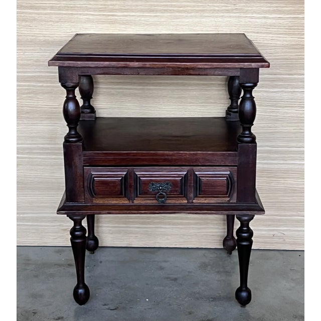 20th century Pair of solid carved Spanish nightstands with one low carved drawer with original bronze pull.