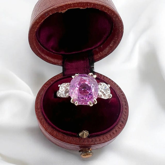 Magnificent trilogy ring in 18 carat gold (750 thousandths). It is adorned with a pink sapphire of Ceylon origin of...