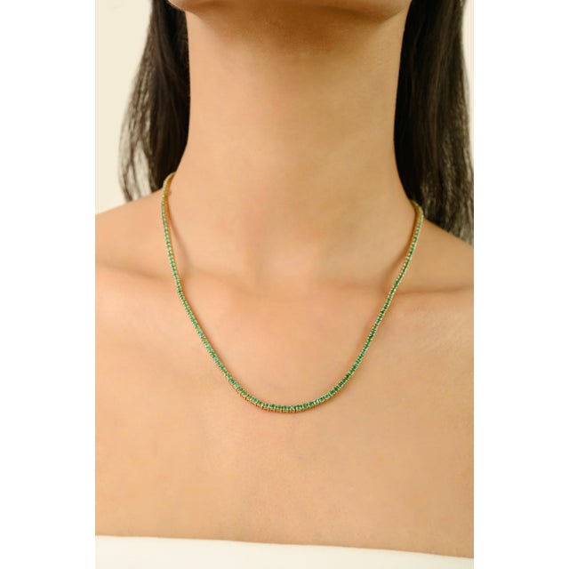 This stunning tennis necklace showcases round-cut natural emeralds totaling 6.82 carats, beautifully set in luxurious 14K...
