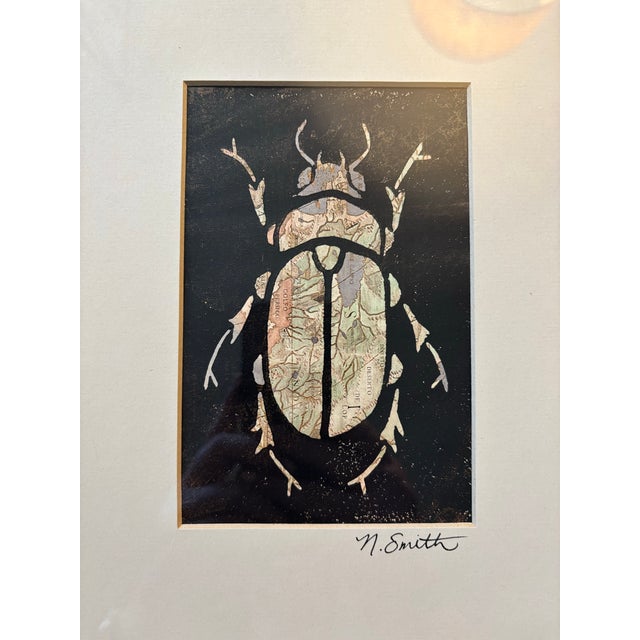 This original beetle print is layered over a fragment of map-based illustration, embedding a sense of place and movement...