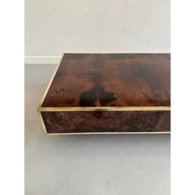 Beautiful coffee table in brown lacquered goatskin with a brass frame. Central leg. This piece is attributed to the...