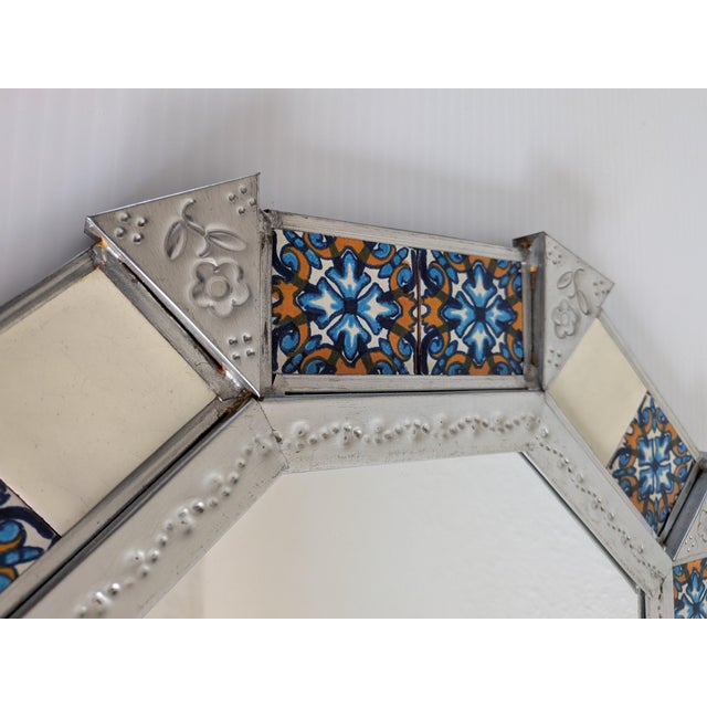 A uniquiley shaped Hojalata (punched tin) with hand painted Talvera Tiles Mirror. It's signed by the artist, which is rare...