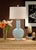 Sleek and refined, cayden lamp features a pale blue hand glazed porcelain bottle vase with a wood finished cap atop a...