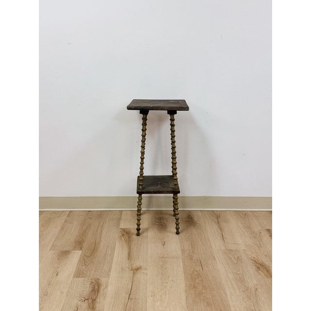 This petite antique side table showcases distinctive spool-turned legs, a hallmark Victorian-era detail that gives the...