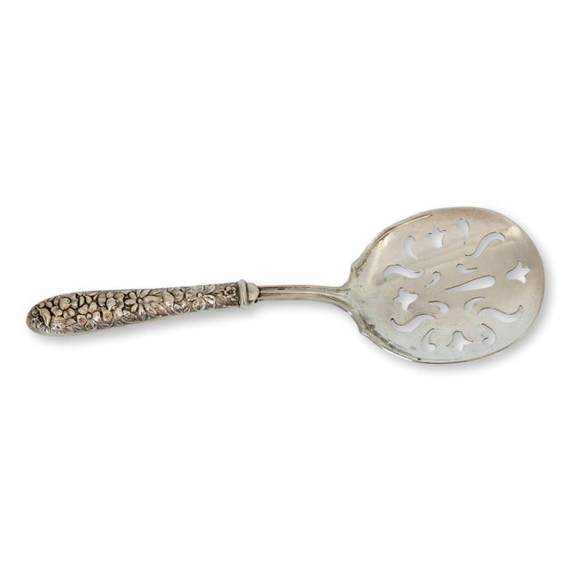 An elegant early twentieth century American tomato server featuring an ornate sterling silver handle with richly detailed...