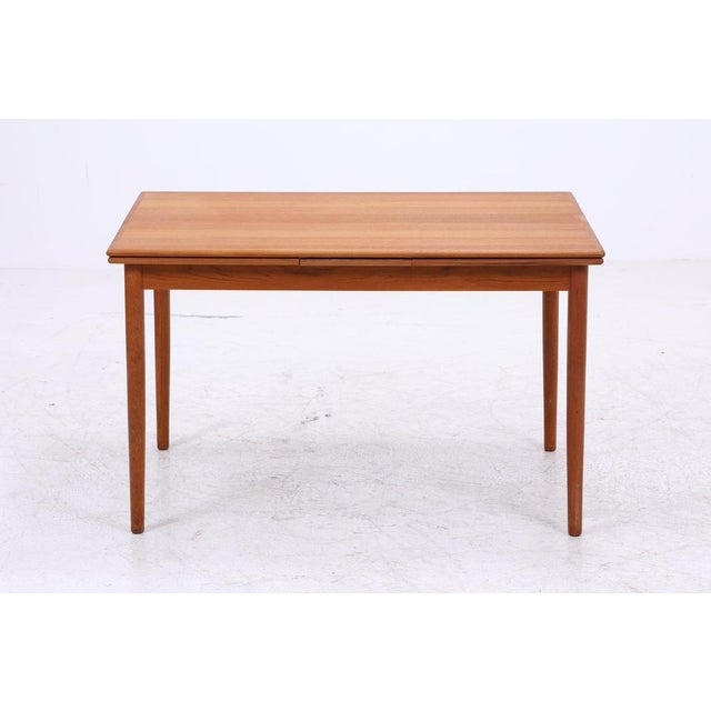 Vintage teak dining table with beautiful, simple lines and a warm wood tone. The two extension leaves can be easily added,...