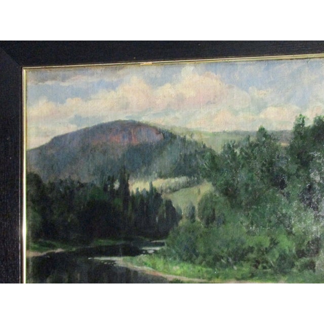 A large sky reflected in a long view of the river as it approaches the hills and moves through a valley. Forests move up...