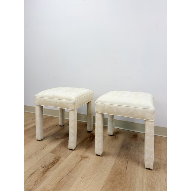 This elegant pair of vintage white upholstered Parsons stools in the style of Milo Baughman are a refined and versatile...