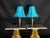 Matching pair of decorative table lamps featuring vibrant turquoise textured fabric shades and dark bronze-tone sculptural...