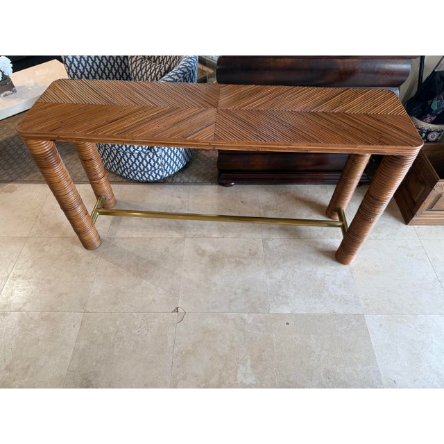 Striking "Edie" Natural Rattan and Brass Console Table designed by Spain’s Mermelada Estudio for CB2. This highly sought-...