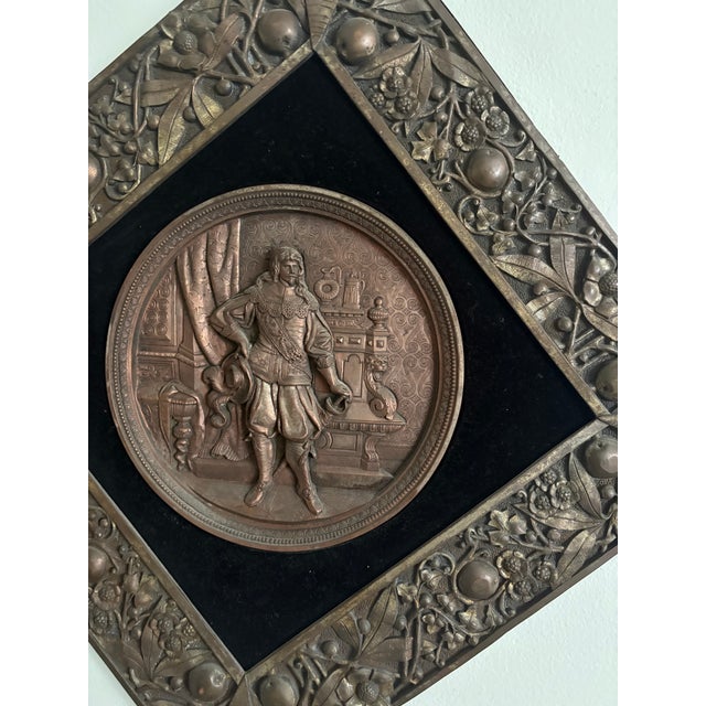 Crafted in a solid metal a rare historical wall plaque showcases a captivating scene of a man in period attire, evoking a...