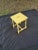 Fresh, painted wood sunshine yellow spot table with finger insert cut out for easy placement in multiple seating areas or...