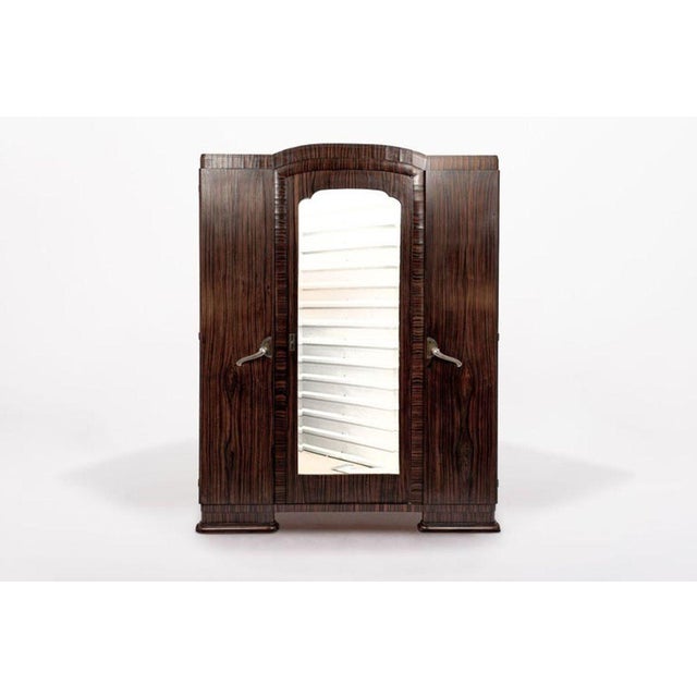 This exquisite antique Art Deco wooden wardrobe armoire cabinet was made in France circa 1940. This tall cabinet is...