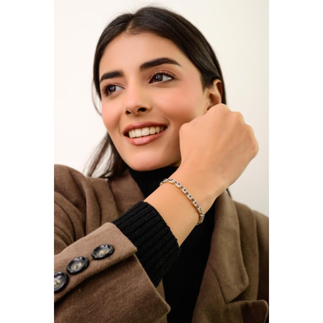 This elegant tennis bracelet features 46 square cut blue sapphires totaling 4.15 carats, set in rich 14K yellow gold. each...