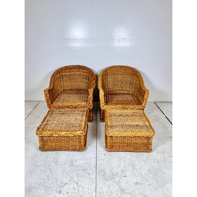 Vintage pair of Wicker Works style lounge chairs with matching ottomans. Rattan and wicker frames with braided wicker...