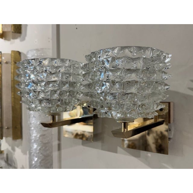 Elegant pair of modern "Rosti" Murano glass and brass sconces. Featuring beautiful glistening glass that gives a lovely...