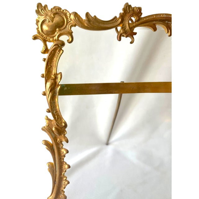 An ornate Rococo Revival picture frame featuring an exuberant gilt-metal surround of scrolling acanthus leaves, shell...