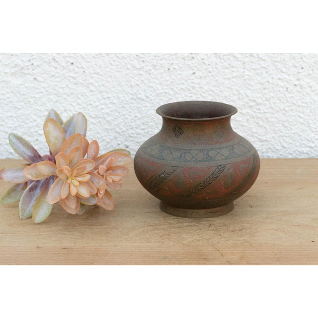A vibrant departure from standard metalware, this antique brass vessel features intricate bands of hand-engraved geometric...