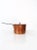 This is an antique copper pot. The four liter double boiler pot features an iron handle, lid with handle, and rim near the...