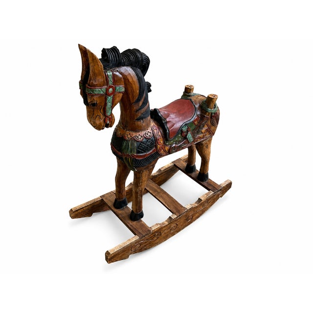 This vintage Southeast Asian rocking horse is a wonderfully decorative hand-carved wood piece with rich painted detail and...