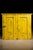 This antique cabinet features a worn yellow paint finish and an arrangement of different cubbies on the inside for the...