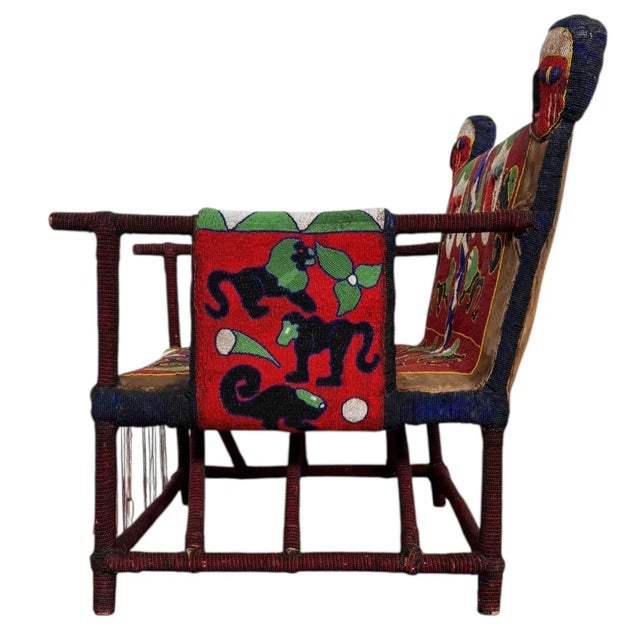 26”W x 33 1/2”H x 30 1/2”D Seat Height: 13 1/4”H Arm Height: 23”H This captivating West African beaded armchair from the...