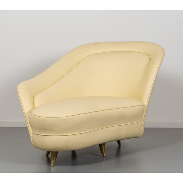 Wooden structure, lacquered wood legs, padding covered in vinyl leather. This piece is attributed to the mentioned...