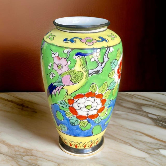 A vibrant vintage Japanese enameled vase that is perfect for display. The vessel is decorated with a colorful Asian design...