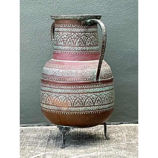 This magnificent vintage copper amphora floor vase is a masterclass in global craftsmanship, featuring intricate hand-...