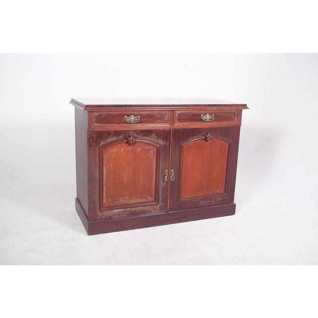 English-style tall sideboard. With two top drawers, each with a yellow metal handle. Below, two doors with recessed ogival...