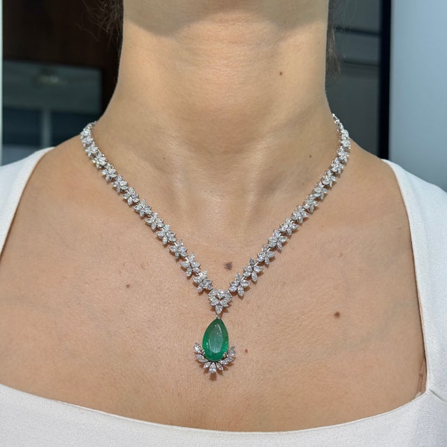 This beautiful statement drop necklace features a 9.81-carat pear-cut natural emerald, set in 14K white gold. It is...