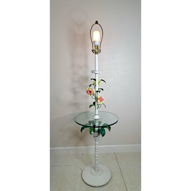 A charming vintage floral toleware floor lamp with an integrated round glass side table. The tall white-painted metal...