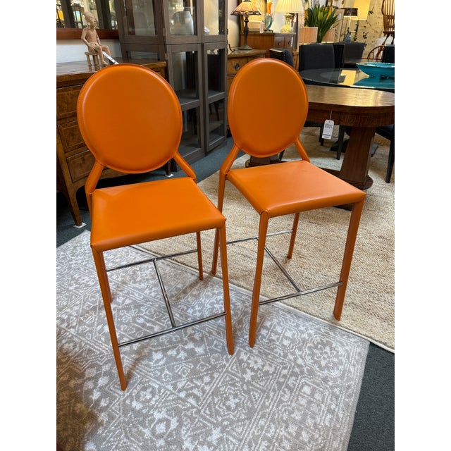 Design Plus Gallery presents a Pair of Orange Isabelle Counter Stools from Euro Style. The Isabella Bar Stool wraps...