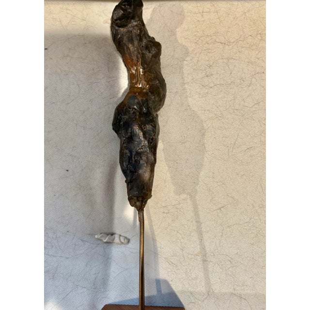 Handsome bronze abstract female sculpture mounted with one single brass rod to a white lacquered wood painted base. It...