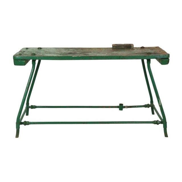 Large green industrial workbench/table featuring a thick wooden top and a metal base; dating from around the mid-20th...