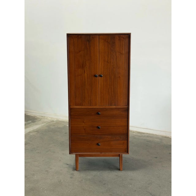 W27 D18 H62.5 This restored vintage gentleman’s chest by Glenn of California features a tall slim silhouette with the...