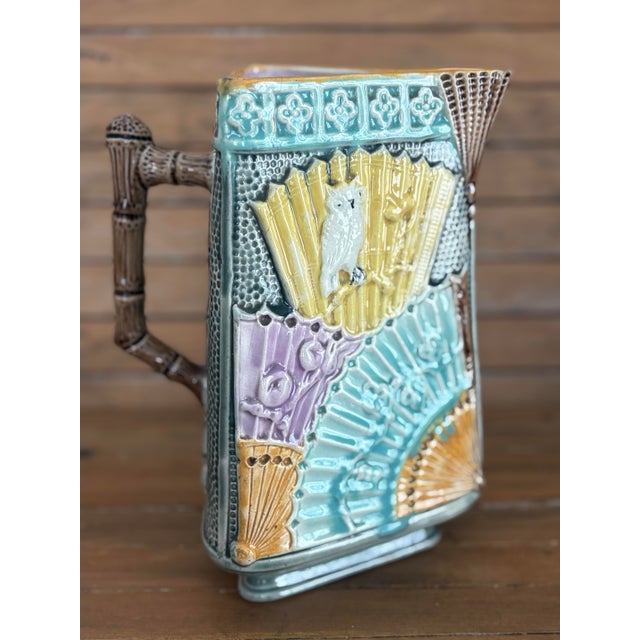 A rare late-19th-century English Aesthetic Movement majolica pitcher featuring exotic birds perched among high-relief...