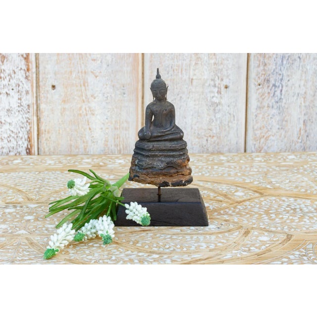 Standing on a custom wood stand, this exquisite Burmese buddha statue is carved from wood with a thin hammered metal alloy...