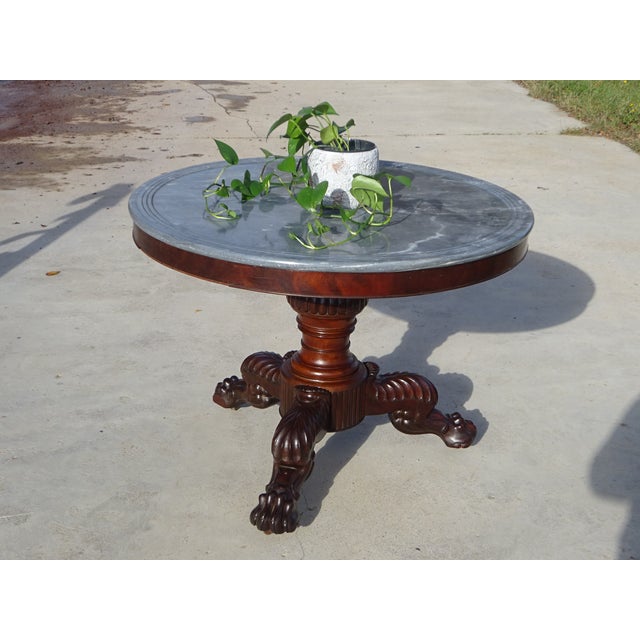 A magnificent small round table from the early 19th century, combining solid mahogany and a beautiful marble top decorated...