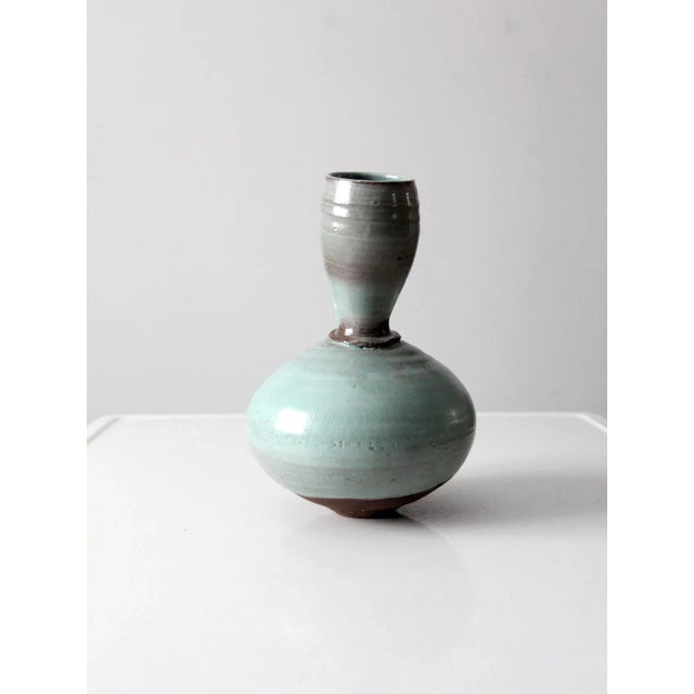 Vintage studio pottery pitcher in soft turquoise glaze with asymmetrical neck and sculptural, organic form. Handcrafted...