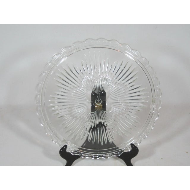 1930's footed round pressed clear glass serving plate for cake's or pastries. The plate has a floral center with a...